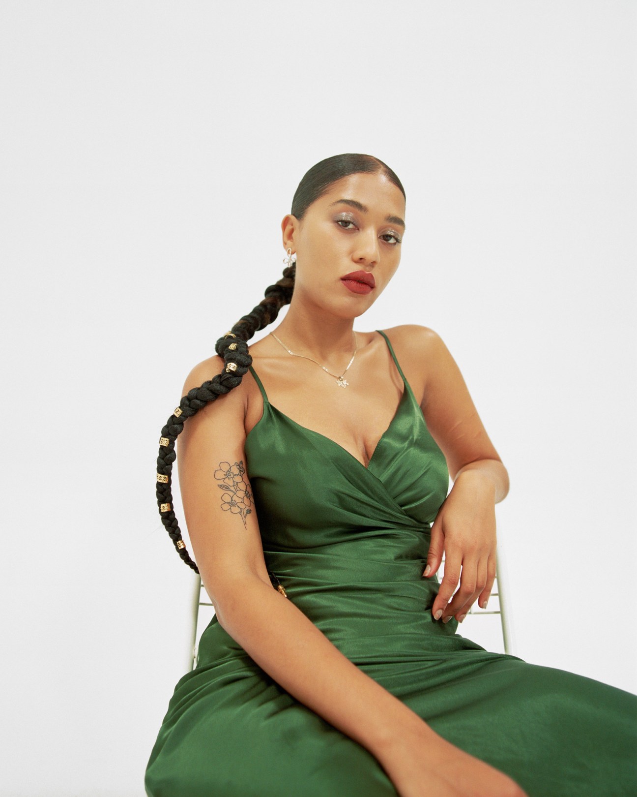 Woman in green dress displaying temporary tattoo on her arm