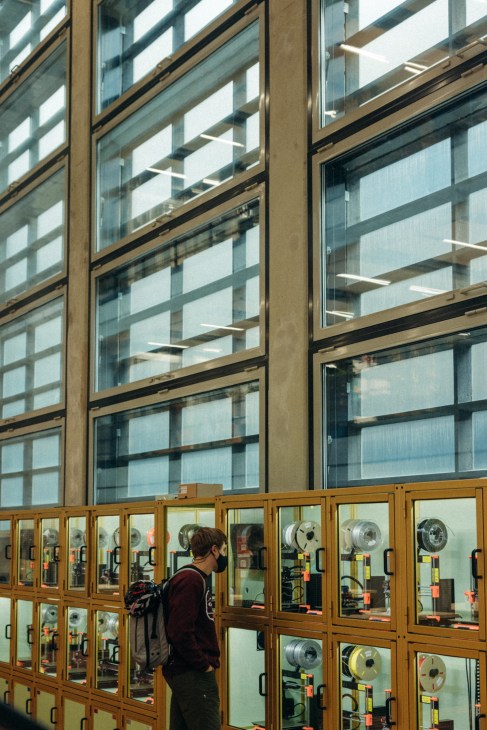 Student examining equipment in glass display cases at ETH Zurich's Student Project House.