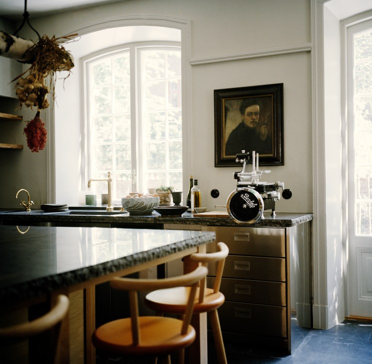 Wooden bar stools with curved backs positioned at kitchen counter by Edward Collinson