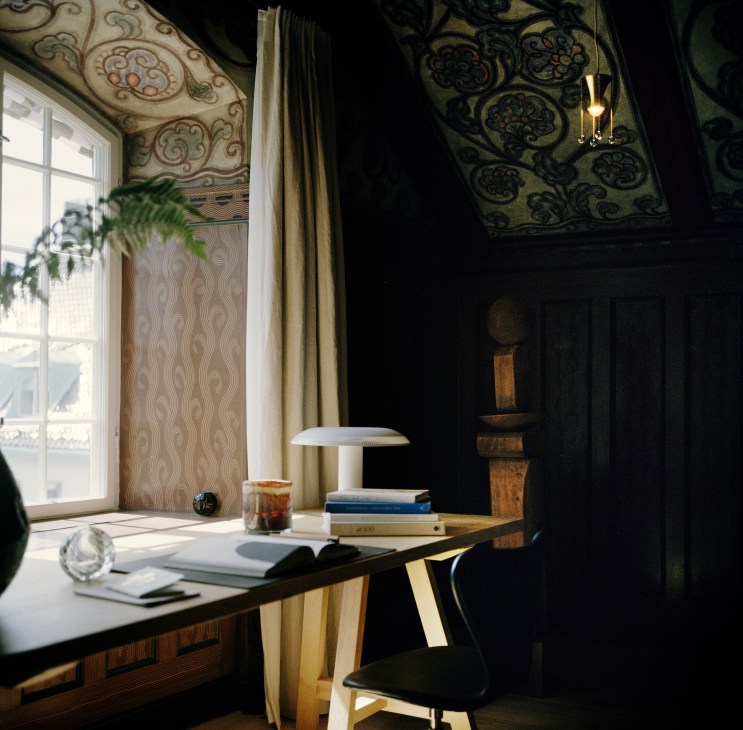 Modern floor lamp next to classic Danish chair in hotel interior
