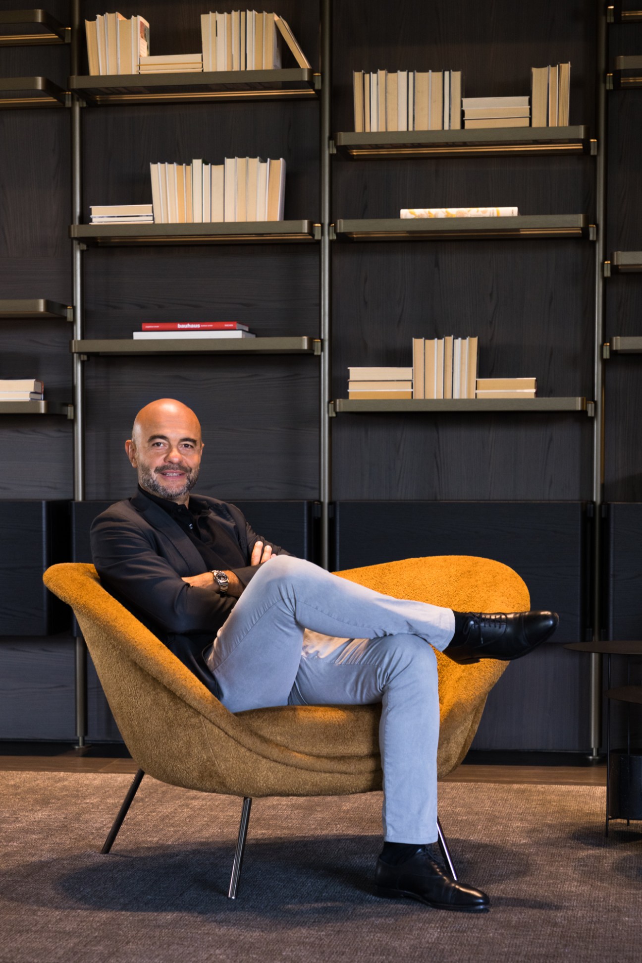 Marco Piscitelli reclining in a large D.154.2 armchair with circular seat cushion and enveloping shell