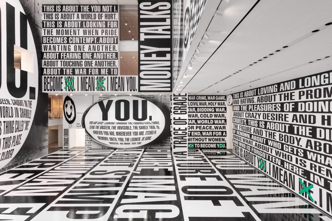 Barbara Kruger's text-based installation covering walls and floors at MoMA with bold black and white typography