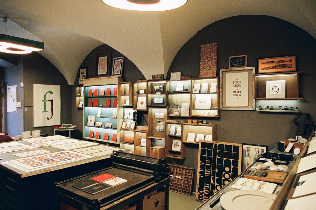 Interior of Tipo Renesansa showing vintage printing presses and wooden type drawers with sans-serif letter lighting fixtures