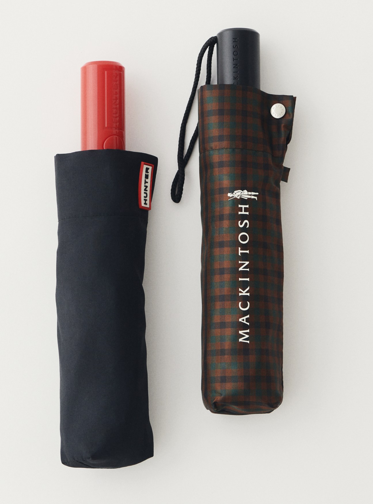 Two umbrellas - one black Hunter umbrella and one brown plaid Mackintosh umbrella