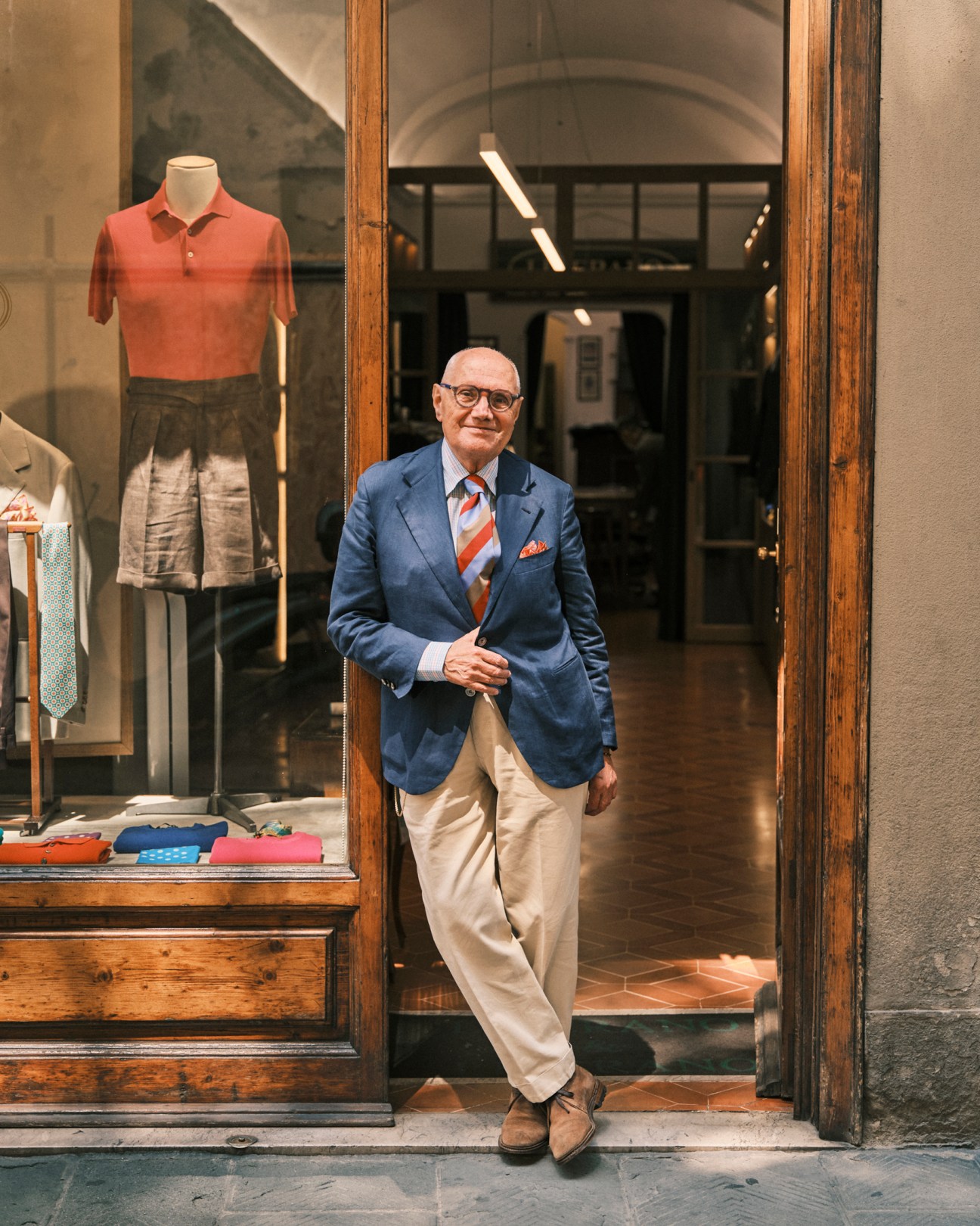 Man in casual blazer and shirt combination standing against historic Italian architecture
