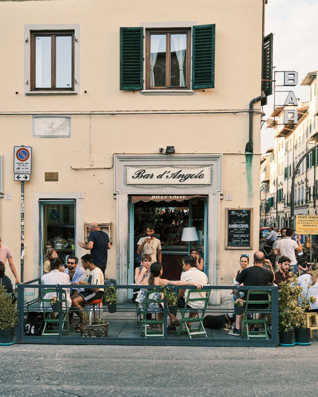 Bar d'AngioIa café in Florence with patrons seated at green tables on an outdoor terrace.