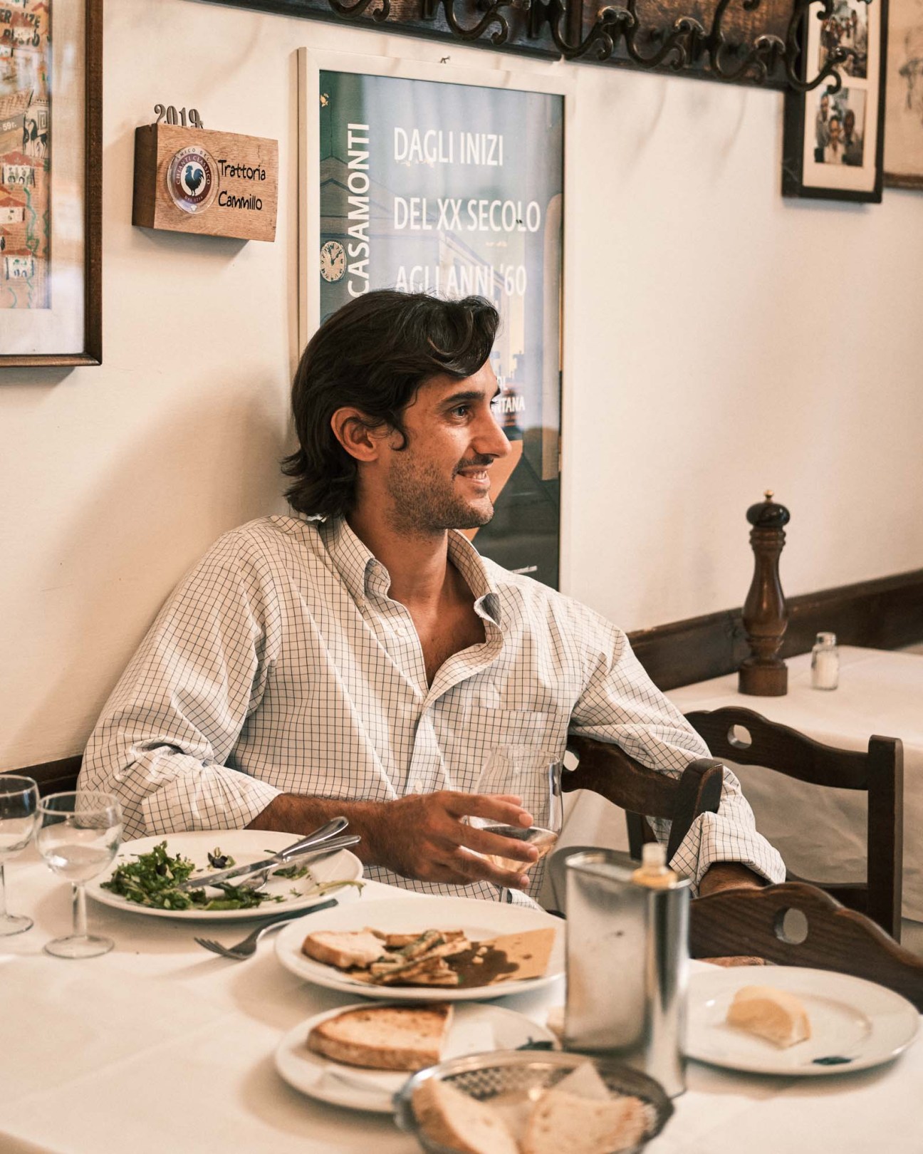 Man in checkered shirt dining at Trattoria Cammillo in Florence.