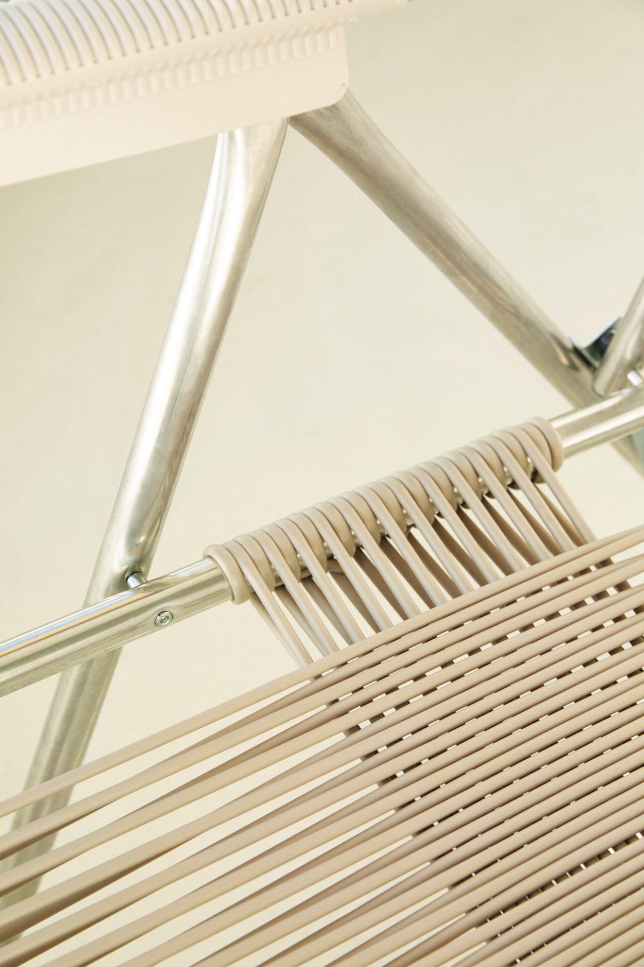 Close-up detail of Fiam Spaghetti deck chair showing metal frame and woven fabric straps.