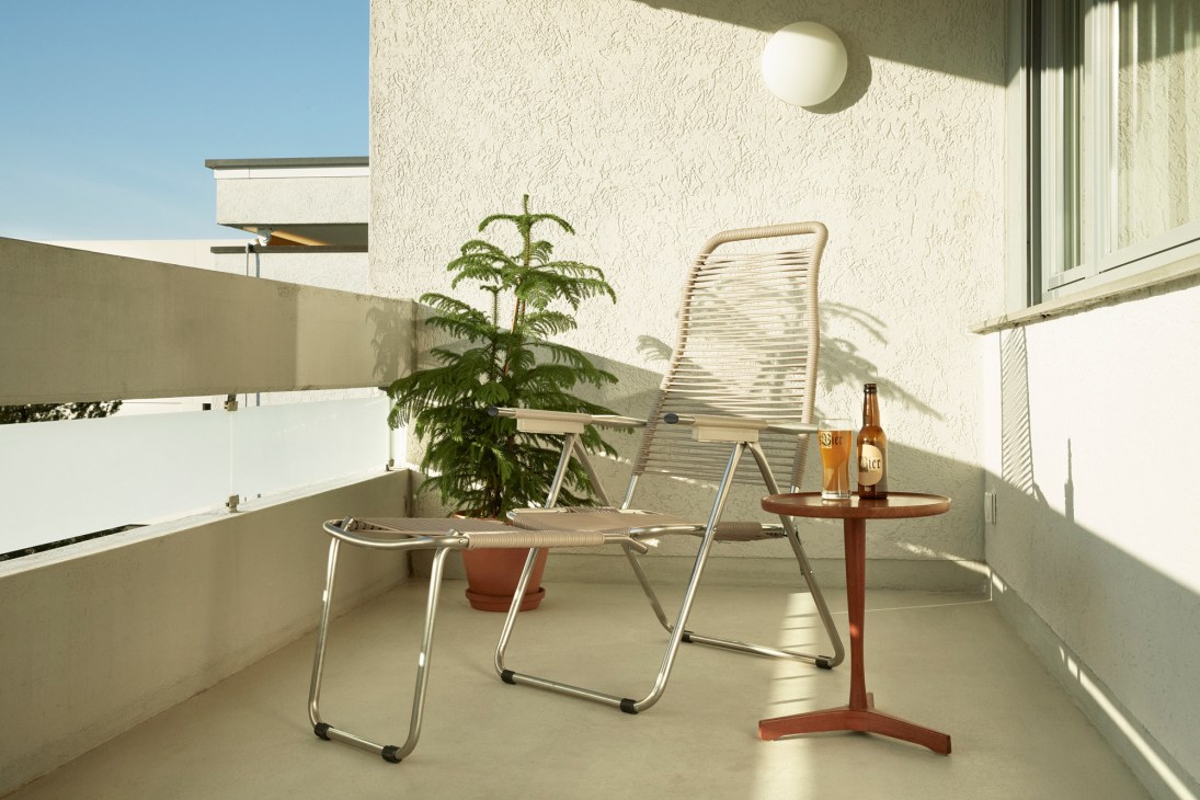 Fiam Spaghetti deck chairs on a minimalist balcony with potted plant and drinks table.