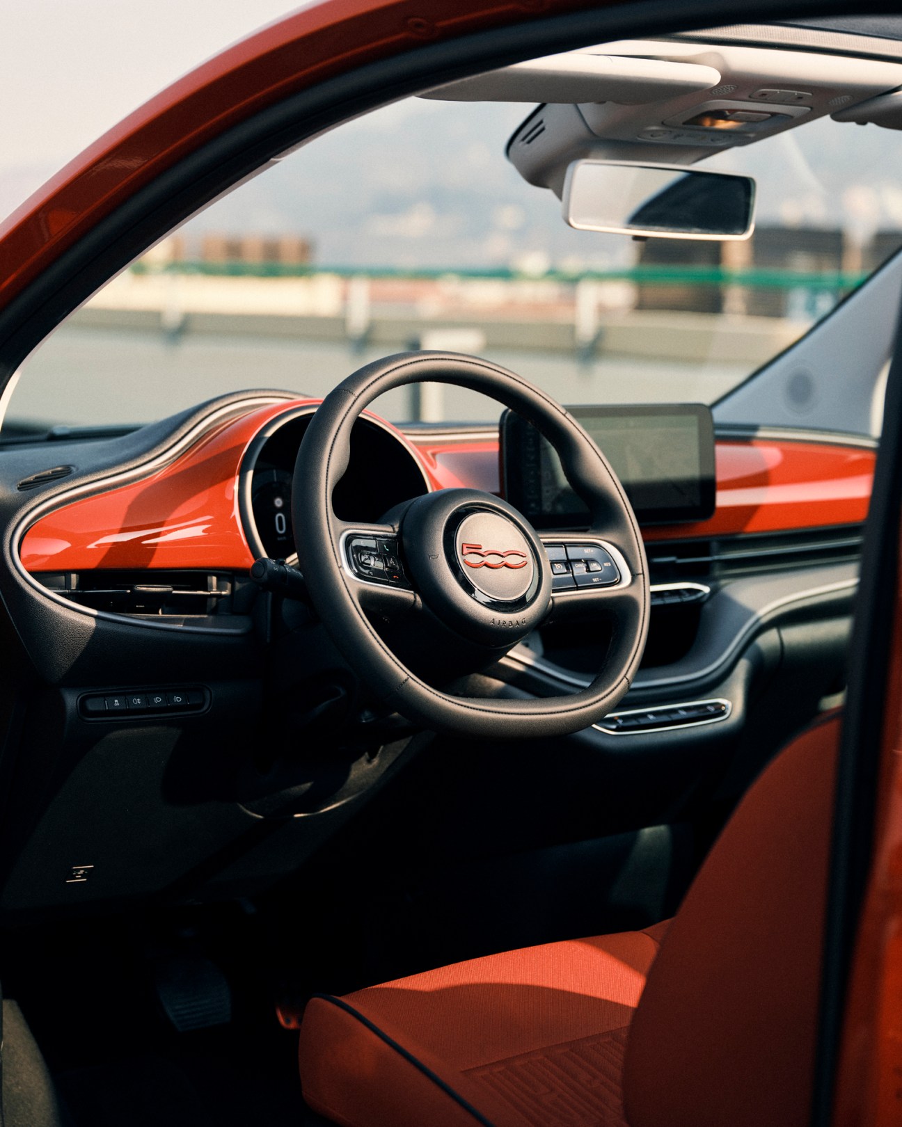 Interior view of the Fiat 500e Project Red edition showing steering wheel and dashboard.