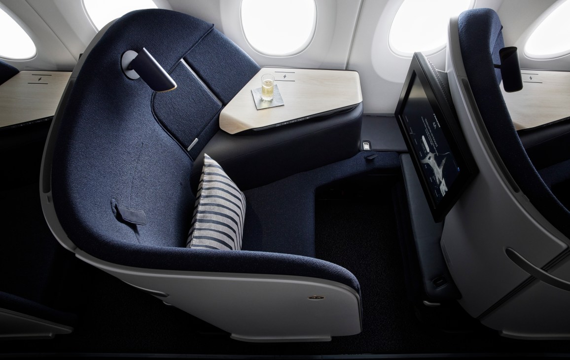Wide view of Finnair Business Class seat showing padded privacy sides and spacious design