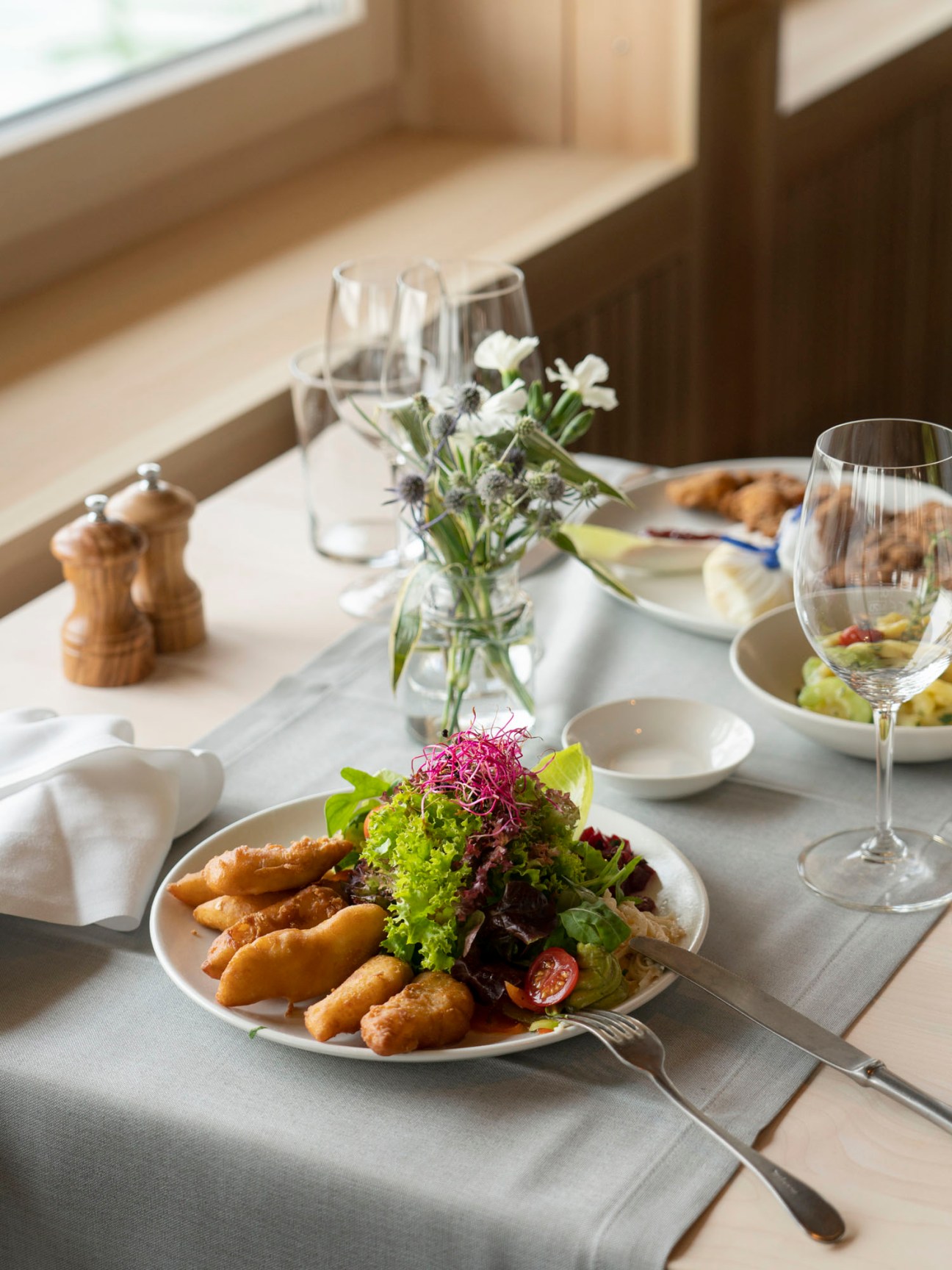 A plate of golden-brown fried fish fillets served as the restaurant's signature Fischknusperli dish