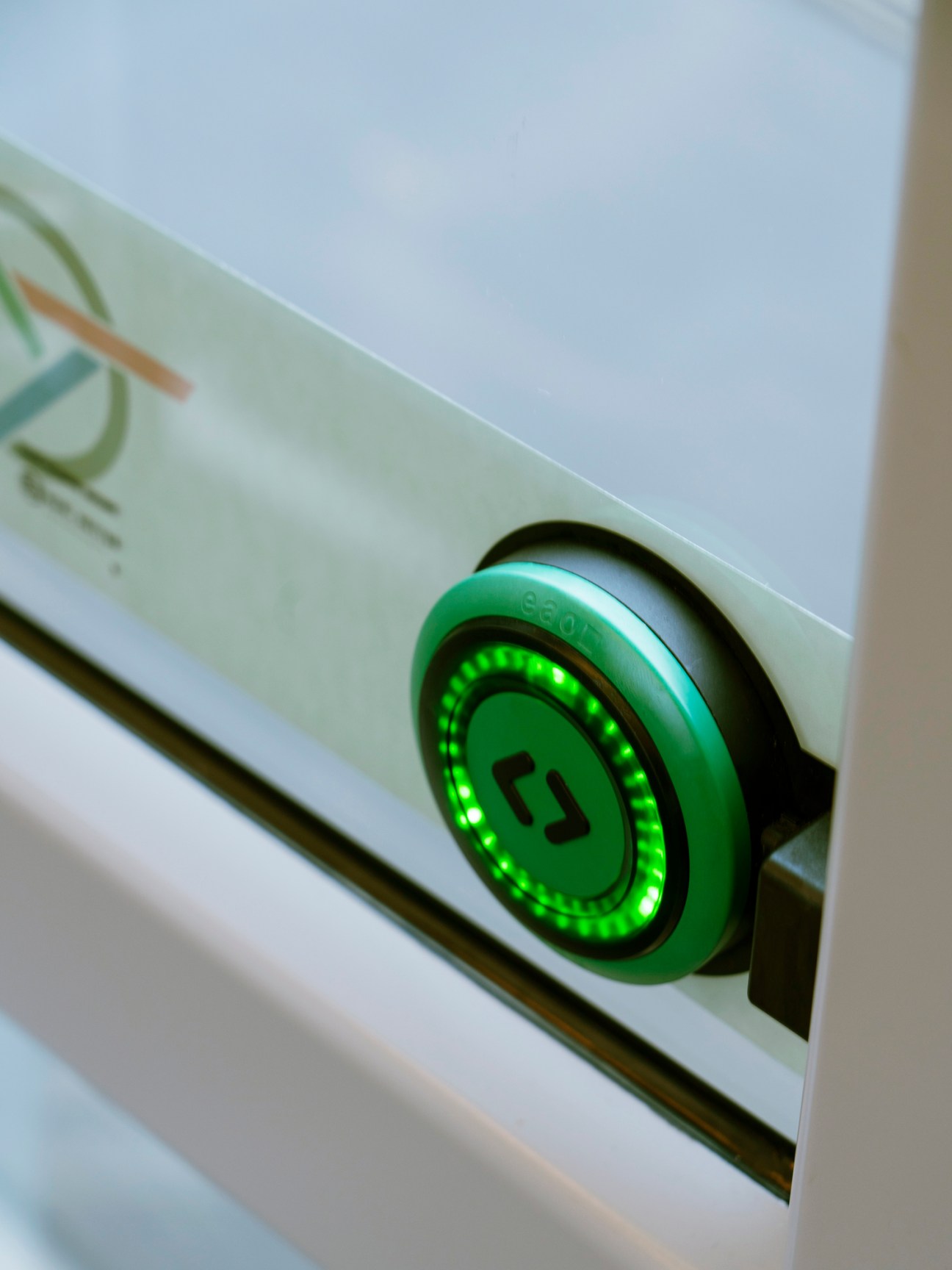 Green illuminated door opener button on Zürich Flexity tram interior.