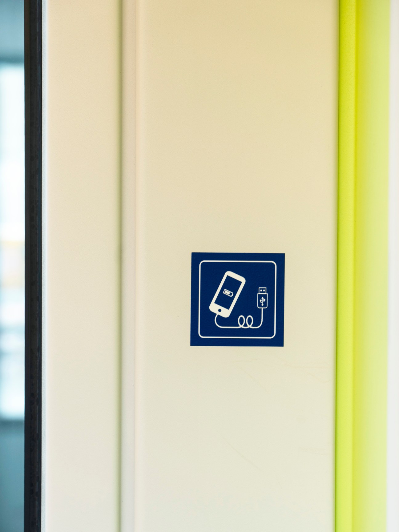 USB charging station sign on a Zürich Flexity tram interior wall.