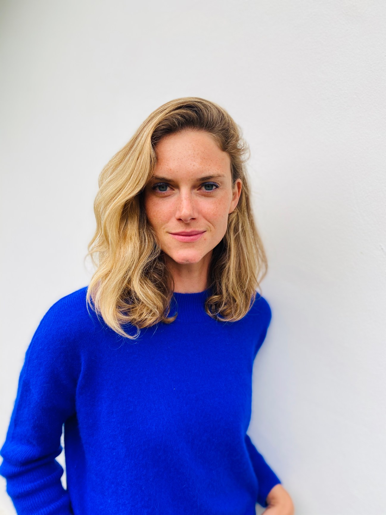 Hanna Israel wearing a bright blue top against a white background