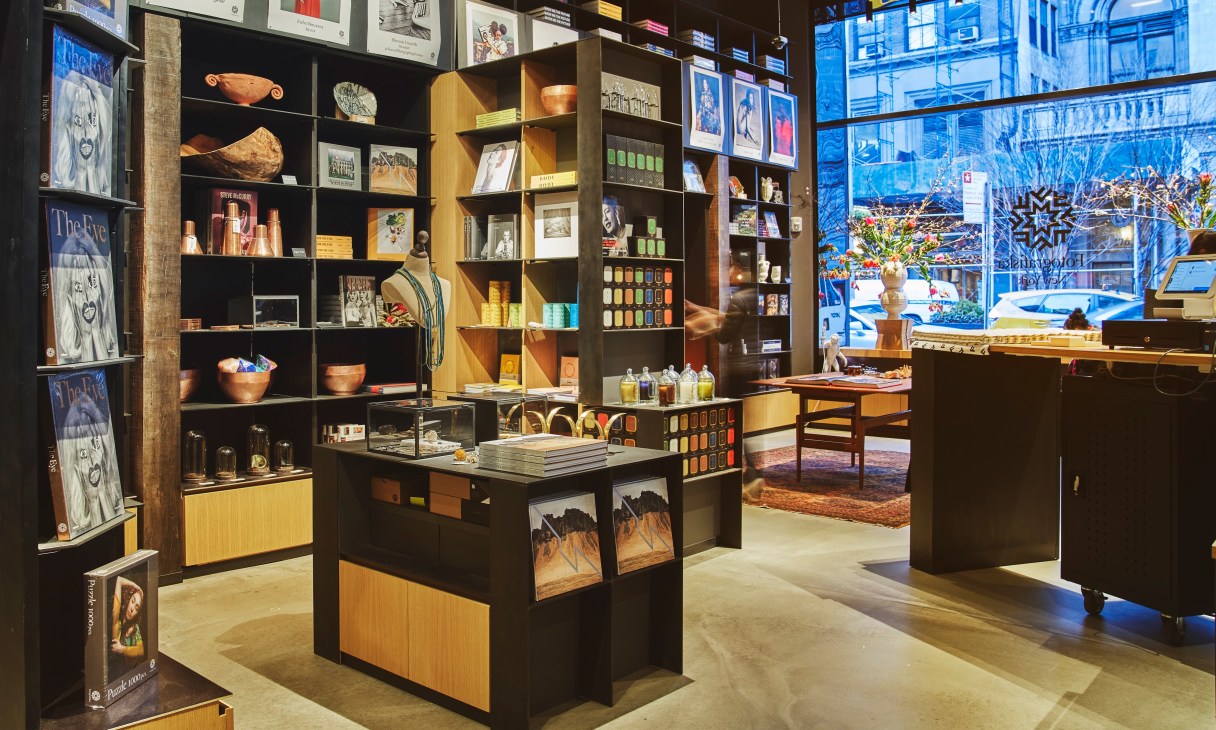 Modern retail space at Fotografiska New York with wooden shelving displaying books, art supplies and merchandise
