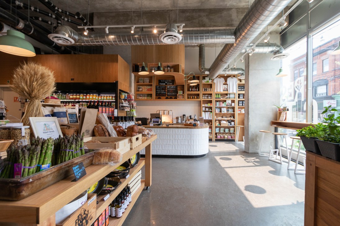 Fresh City Farms store interior with wooden shelving, produce displays, counter, and large windows.