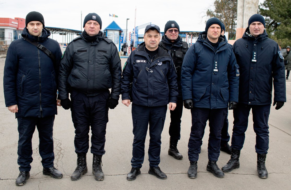 Rosian Vasiloi, chief of Moldovan border police, stands with five uniformed team members in dark winter clothing