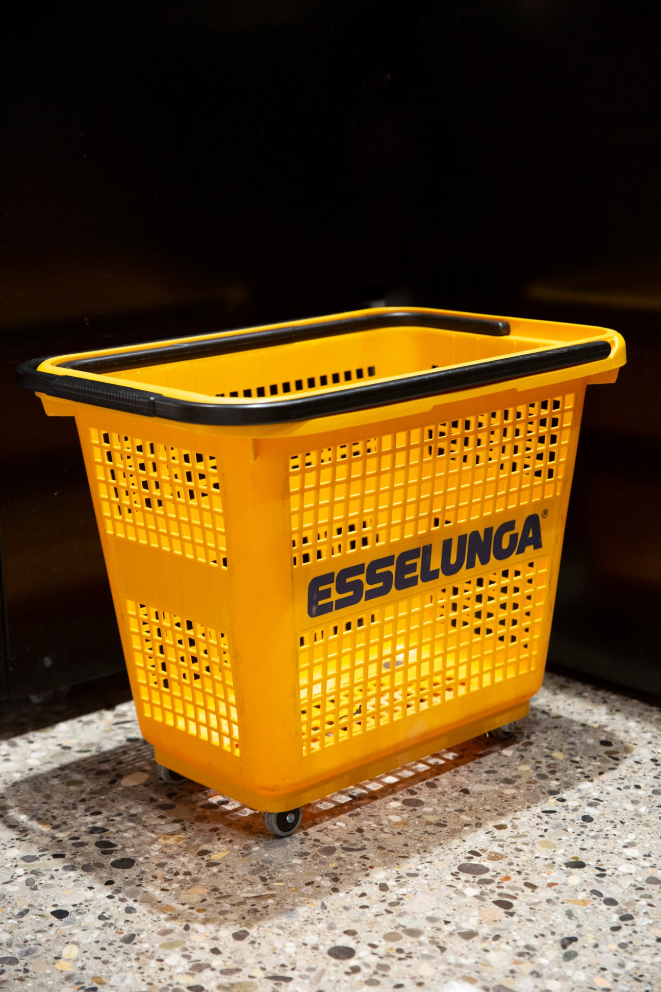 Yellow plastic shopping basket with wheels and handle, branded with ESSELUNGA logo
