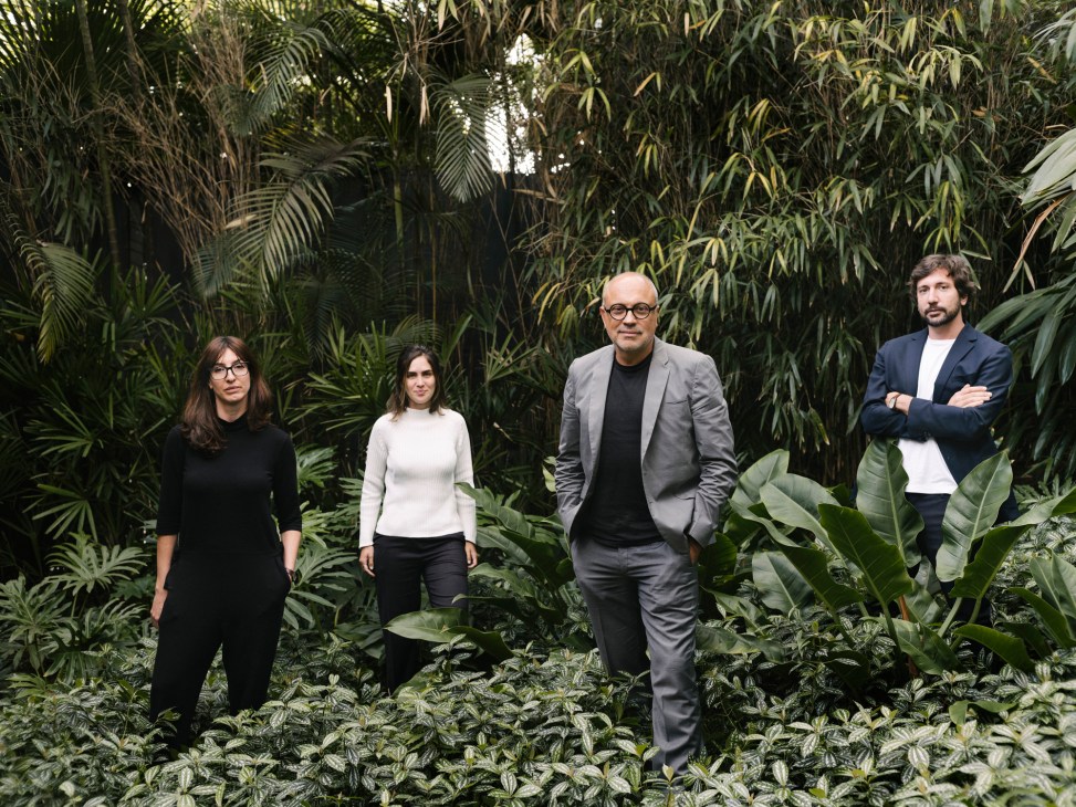 Four people from Studio Arthur Casas team standing in lush tropical garden setting