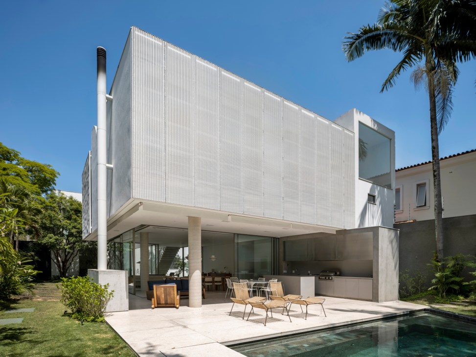 Modern concrete house with clean lines and geometric forms set among tropical vegetation
