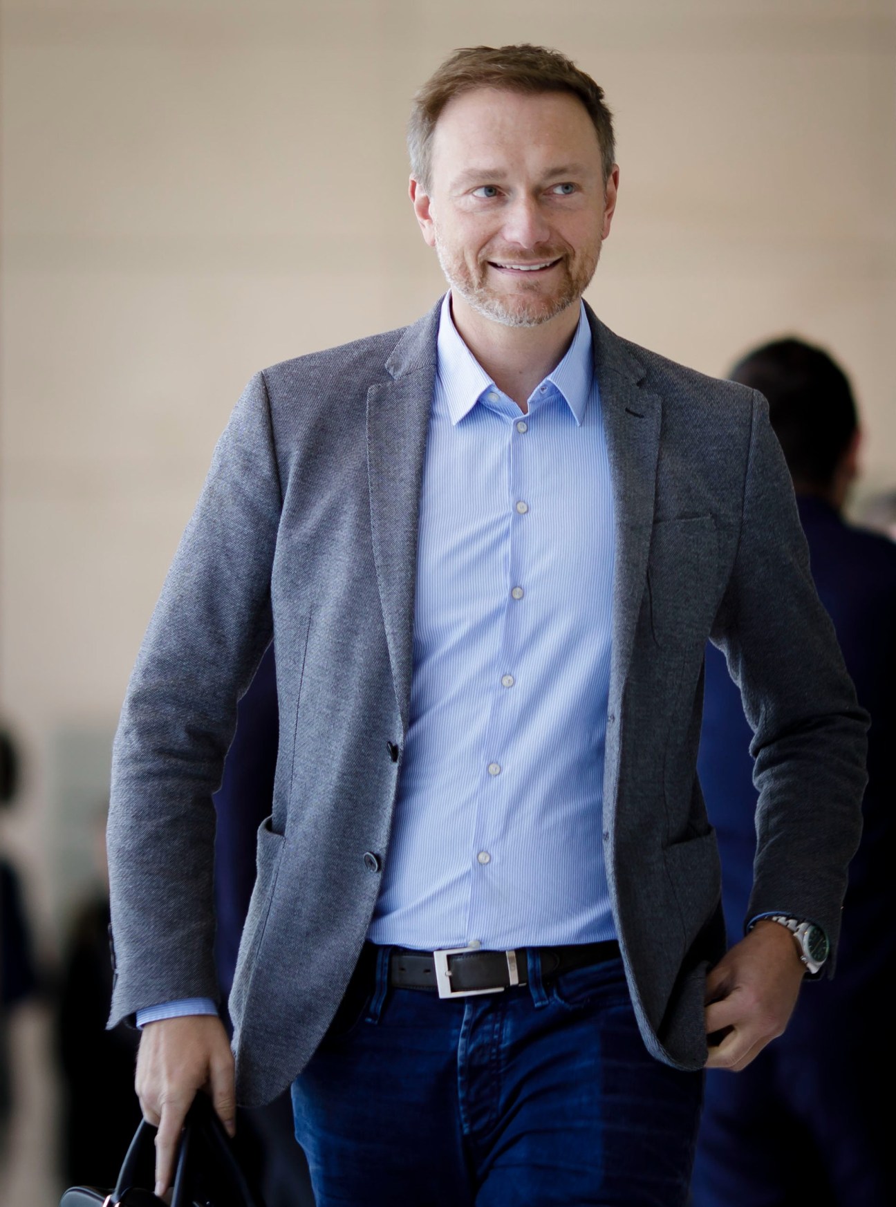 Christian Lindner in grey blazer and blue shirt smiling at camera in professional setting