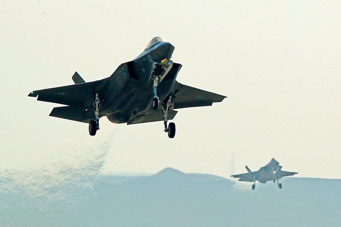 Two F-35 fighter jets flying in formation against a cloudy sky