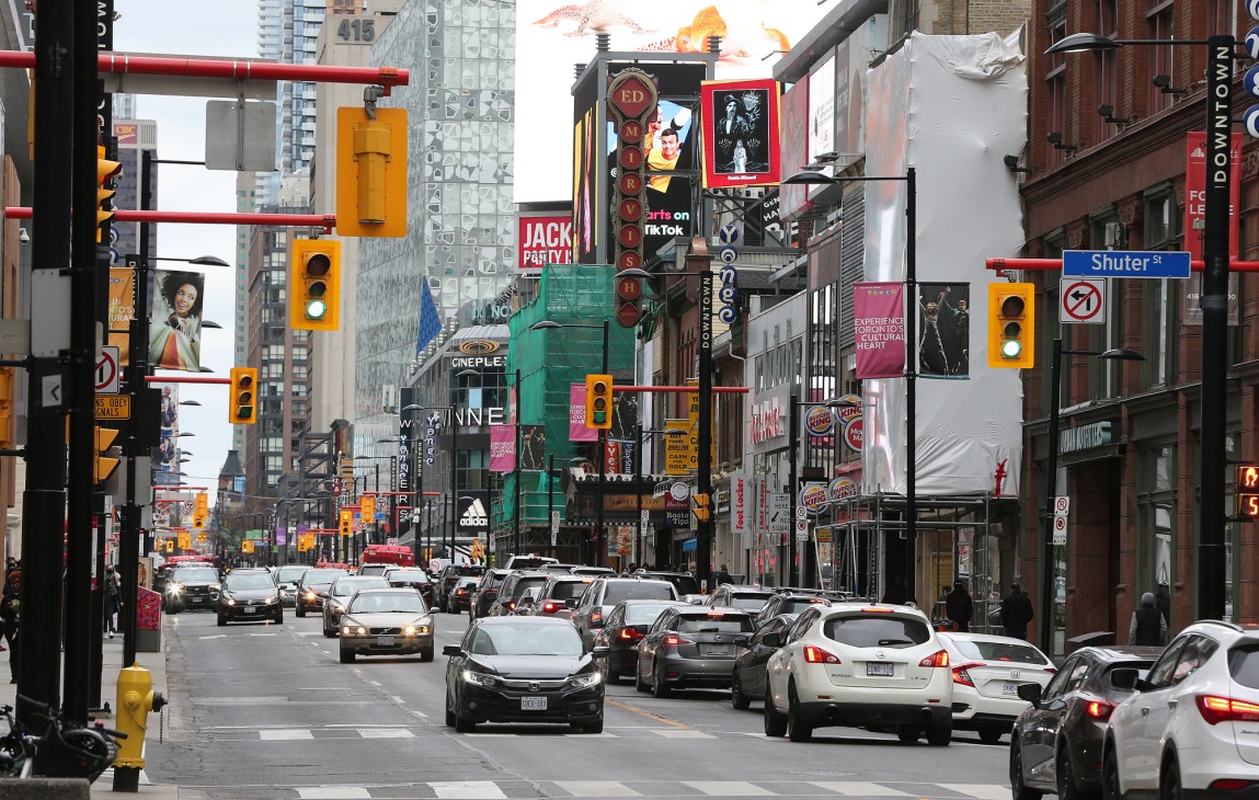 Busy urban street with heavy traffic and commercial signage in Toronto