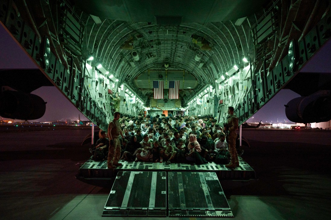 US military personnel assist crowds of evacuees boarding a C-17 aircraft at Kabul airport during Afghanistan evacuation