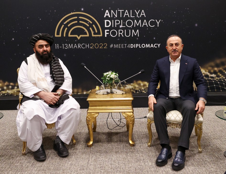 Amir Khan Muttaqi and Turkish Foreign Minister Mevlut Cavusoglu sitting in ornate chairs during bilateral meeting