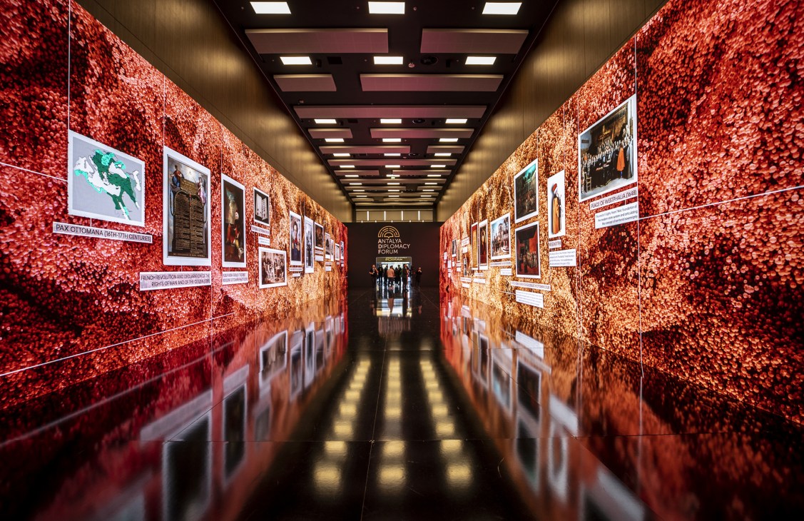 Museum-style hallway display showing historical Turkish diplomatic timeline with photos and text panels on red walls