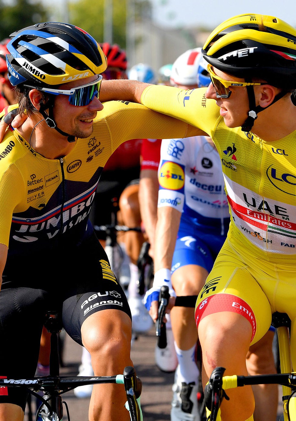 Two cyclists in yellow jerseys embracing after a Tour de France stage