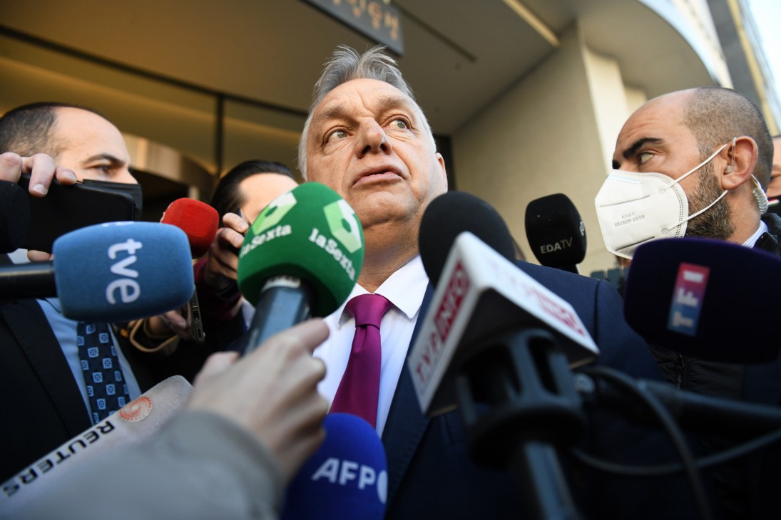 Viktor Orbán surrounded by journalists with microphones at a press conference