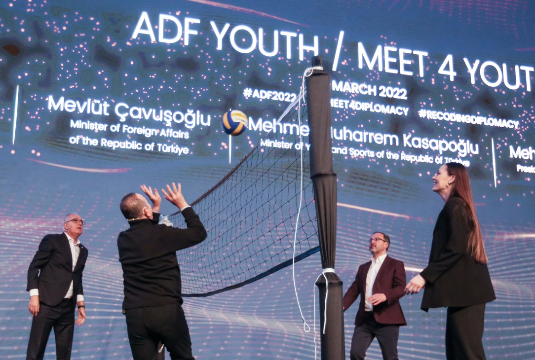 Government officials playing volleyball with a net set up during the ADF Youth Meet 4 Youth diplomatic event