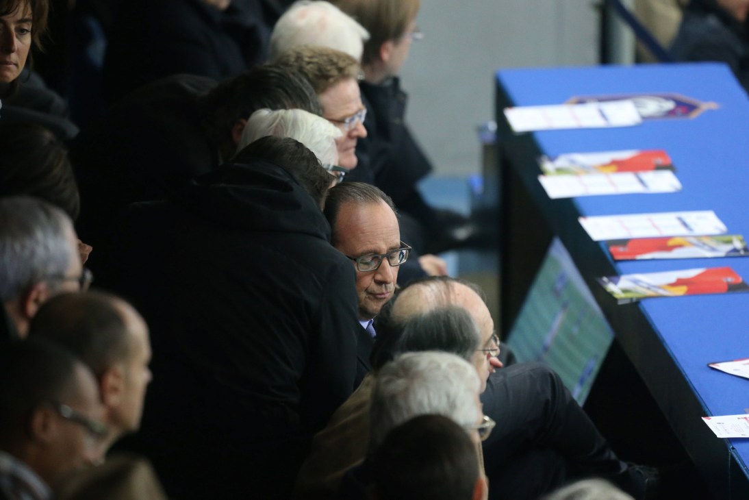 François Hollande seated among spectators at the Stade de France during the football match