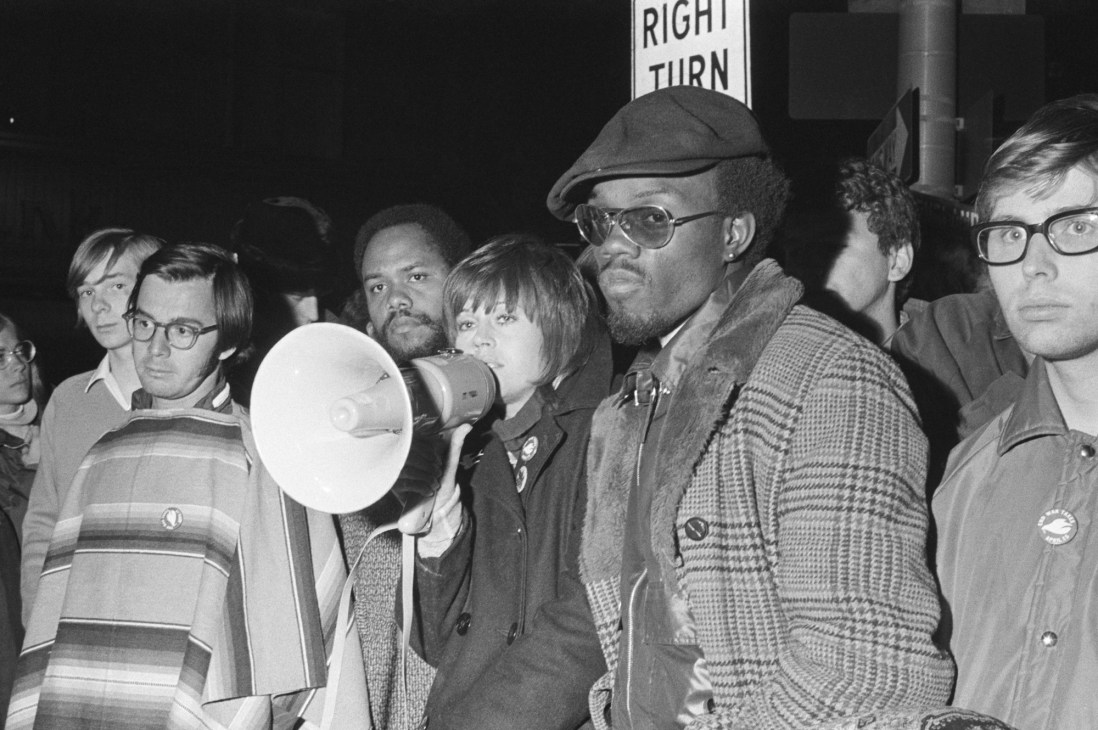 Young Jane Fonda speaking at anti-war rally in 1970 with raised fist