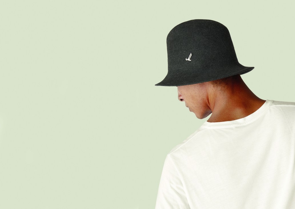 Person wearing Mühlbauer Traveller hat in grey with white logo on cream background