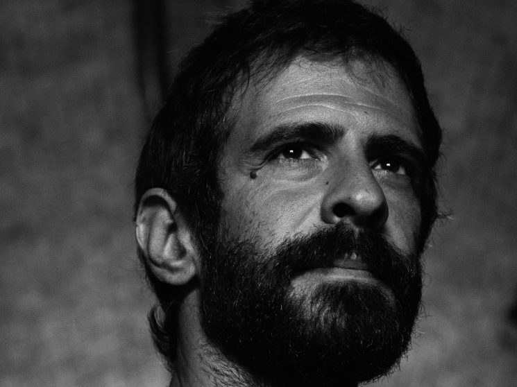 Portrait of Giulio Rubino, Italian crime reporter, looking upward in black and white