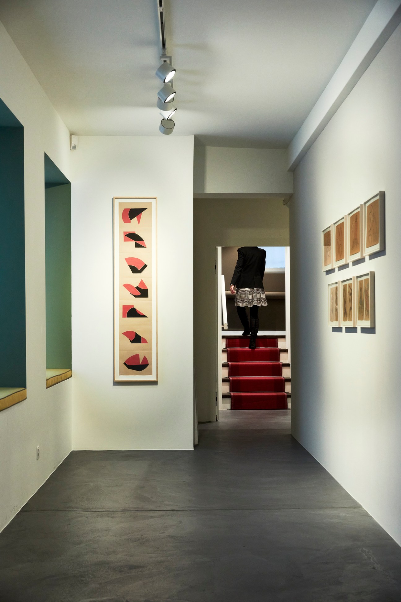 Gallery visitors viewing contemporary artworks on white walls in modern exhibition space