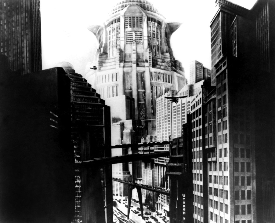 Black and white still from 1927 film Metropolis showing towering Art Deco skyscrapers and vertical city architecture