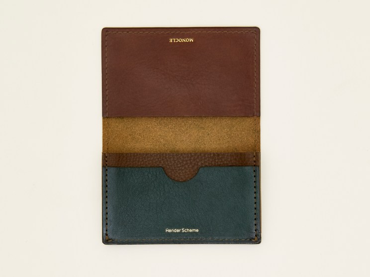 Multi-colored leather card case with brown, olive and teal panels displayed flat against beige background