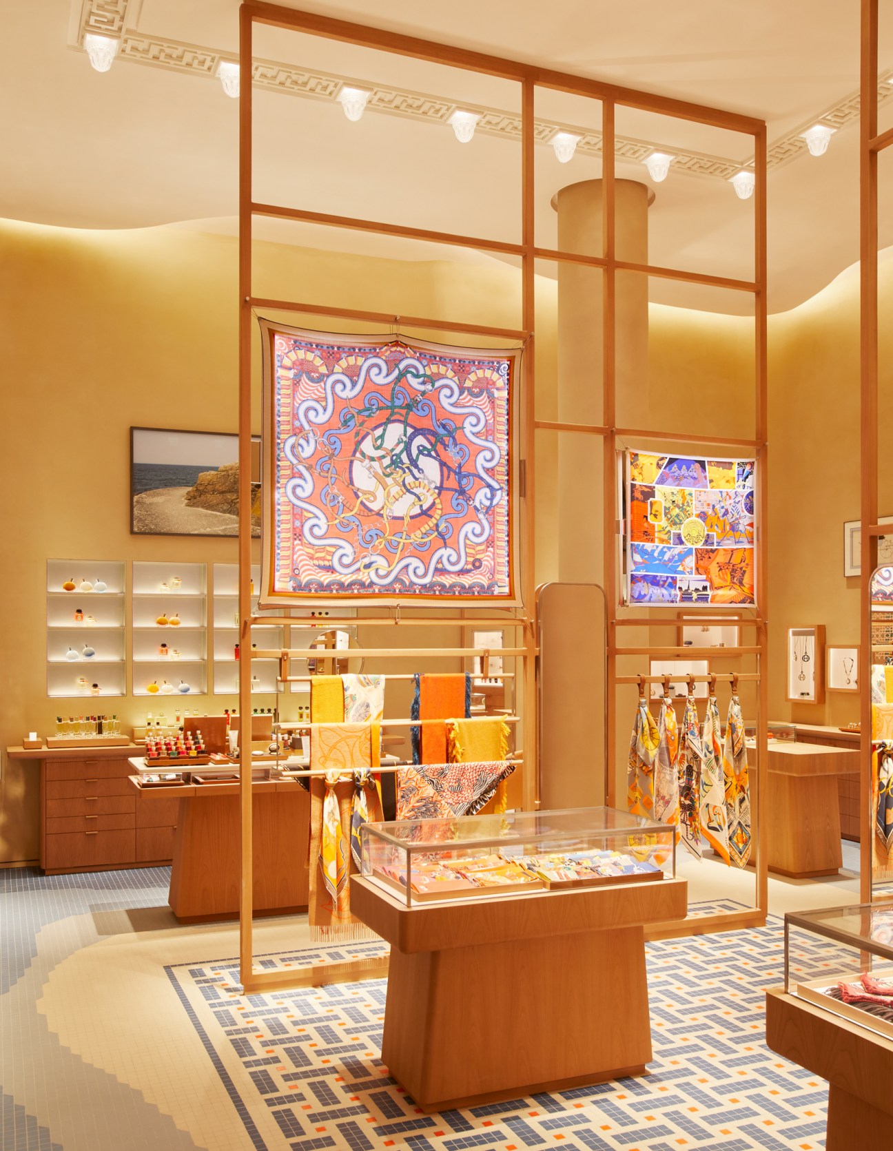 Hermès Barcelona boutique interior with warm sandy stucco walls, wooden display structures, and mosaic flooring.