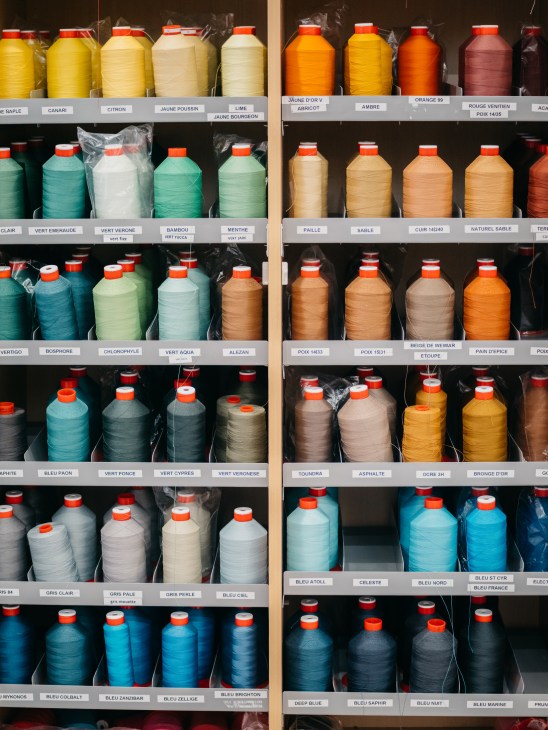 Array of colorful thread bobbins arranged in organized rows