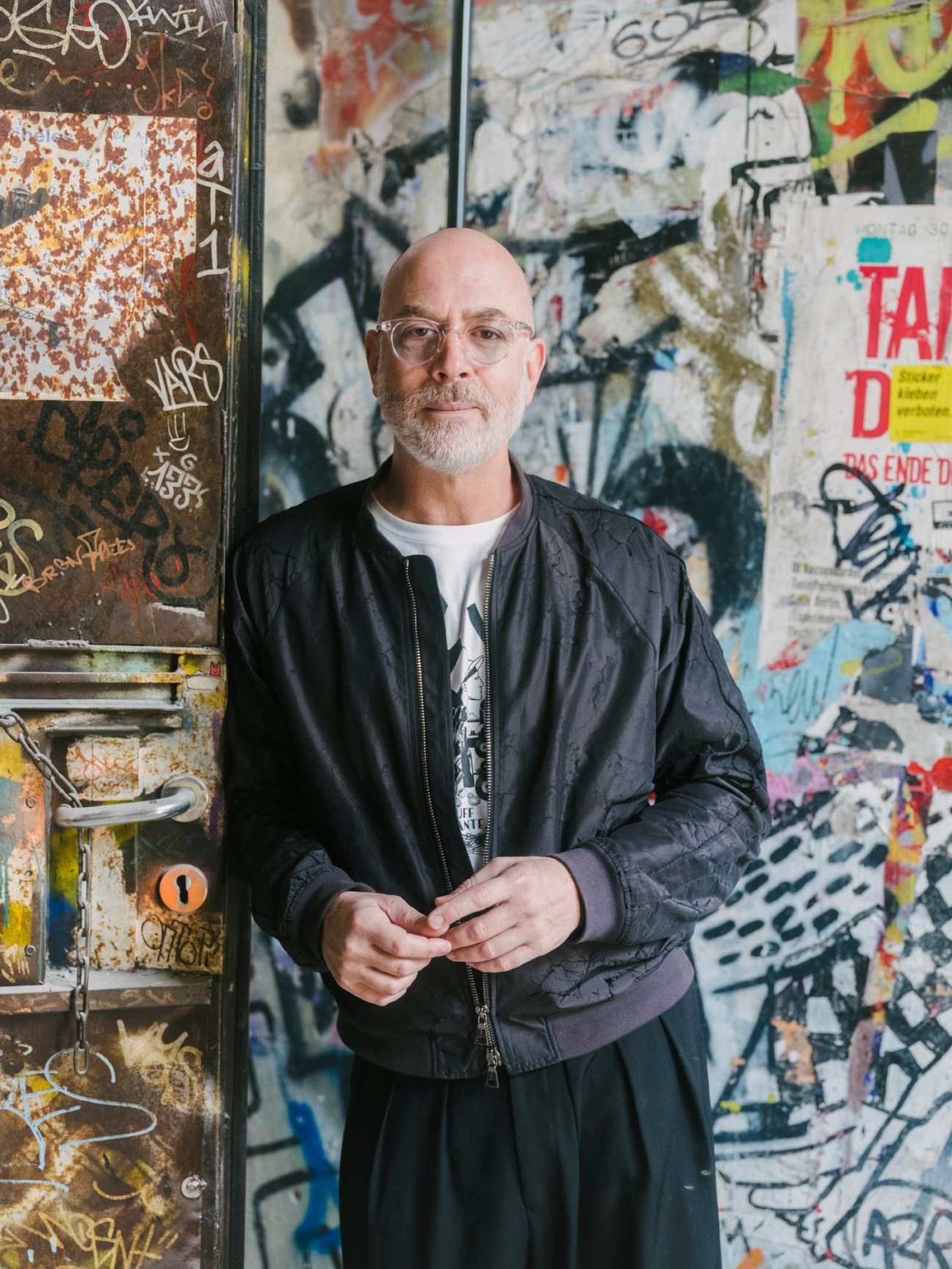 Yoram Roth, executive chairman of Fotografiska museum, posing against a graffiti-covered wall in Berlin.
