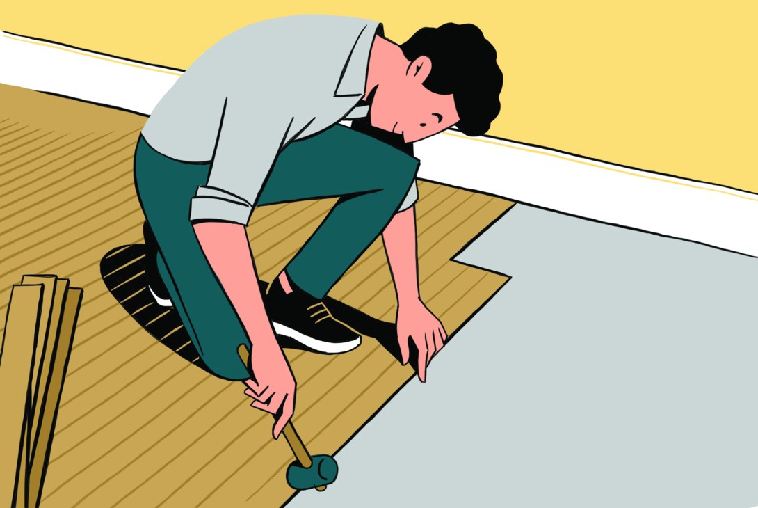 An illustrated black-haired man in a gray shirt and green pants lays wooden paneling over a concrete floor with a hammer.