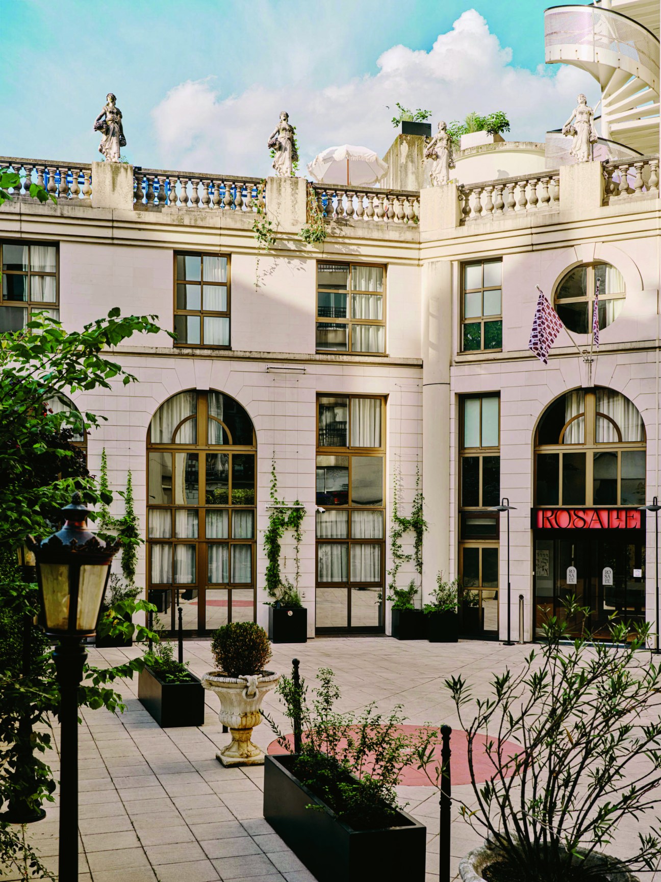 Inner courtyard at Hotel Rosalie Paris featuring classical architecture with statues and balustrades