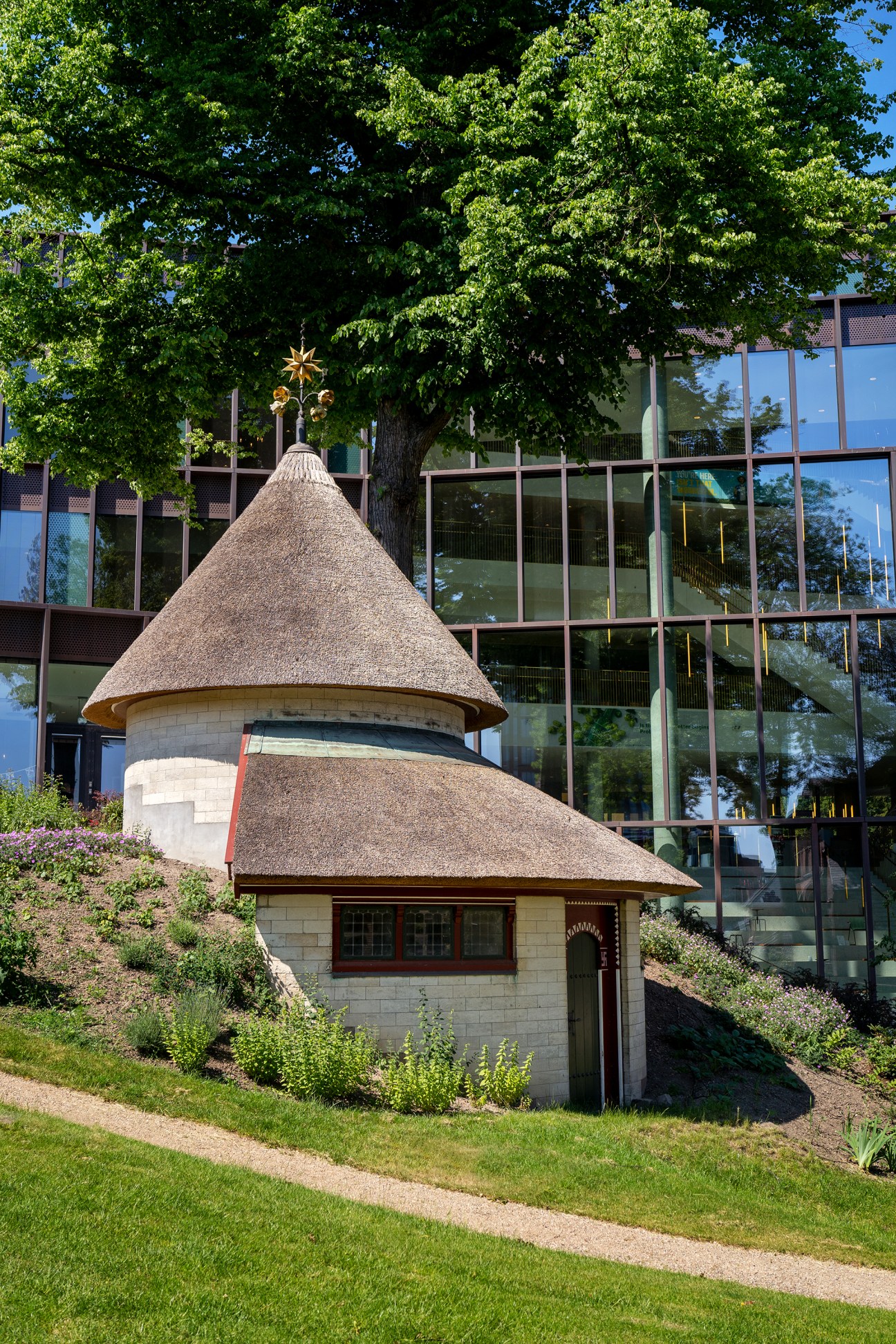 Historic thatched-roof ice house building in courtyard garden