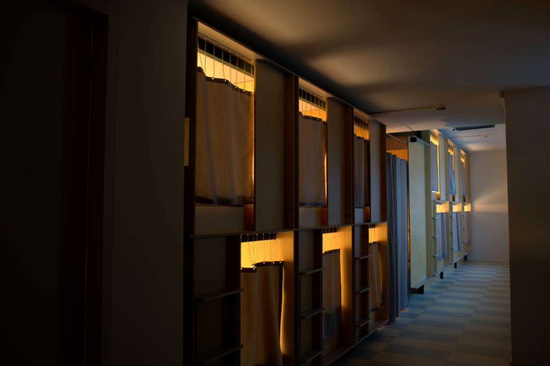 Interior view of a single capsule bed pod with clean white linens and modern amenities