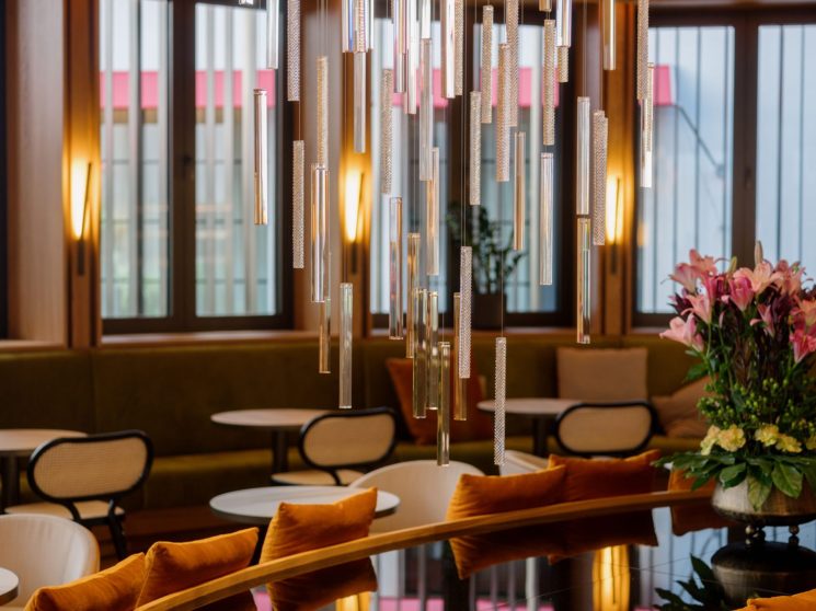 The Julius Prague hotel interior with glass pendant lights and orange velvet seating
