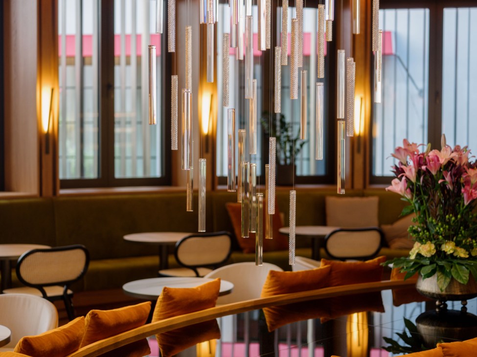 The Julius Prague hotel interior with glass pendant lights and orange velvet seating